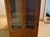 a wooden cabinet with a glass door in a room