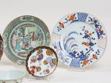 several plates and bowls are sitting on a stand on a white surface