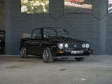 une voiture noire garée dans un garage à côté d'une voiture rouge