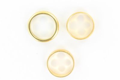 trois bagues en or et en nacre sur fond blanc