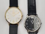 deux montres noires et blanches posées l'une à côté de l'autre sur une surface blanche