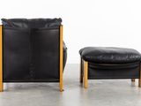 black leather lounge chair and ottoman with wooden legs and foot rest