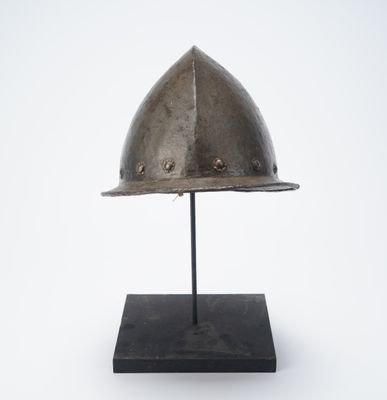 an antique helmet on a stand on a white background