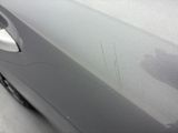 the car is parked on the side of the road with the paint peeling off