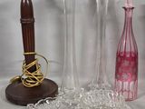 three vases and a candle holder on a table