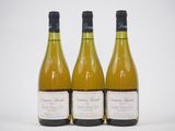 trois bouteilles de vin blanc posées les unes à côté des autres sur une table