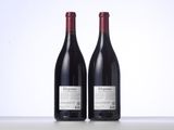 two bottles of red wine sitting next to each other on a table