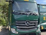 deux camions verts garés l'un à côté de l'autre sur un parking