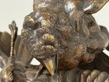 bronze statue of a bird with a baby bird on it ' s back