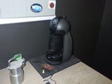 une cafetière posée sur une table à côté d'une tasse