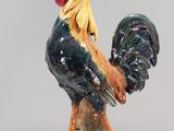 a figurine of a rooster on a clear base