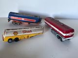 trois camions miniatures posés les uns à côté des autres sur une table