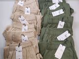 plusieurs paires de pantalons kaki pour homme, avec leurs étiquettes de prix encore attachées