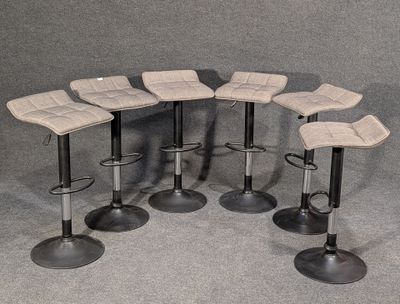 six tabourets sont disposés en cercle sur un fond gris