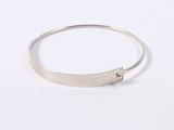 a close up of a silver bracelet on a white surface