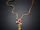 a gold necklace with pink and white beads and a gold chain