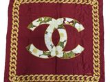 un foulard Chanel orné de fleurs blanches et de chaînes dorées