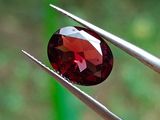 un gros plan sur un diamant rouge tenu par deux tweets