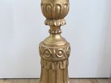 a gold vase sitting on top of a wooden table