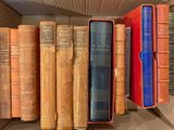 de nombreux livres anciens dans une boîte posée sur une étagère