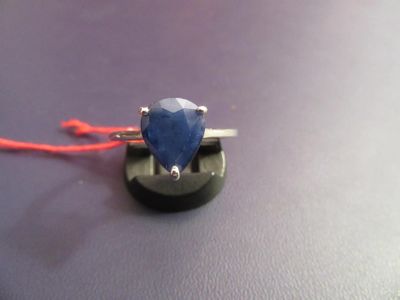 a ring with a blue stone sitting on top of a table