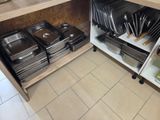 de nombreux plateaux et plats sur les étagères de la cuisine