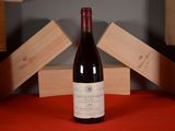 a bottle of wine sitting on a red table cloth