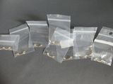 five bags with gold rings on them sitting on a table