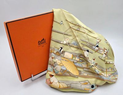 une boîte orange sur laquelle est posé un foulard, à côté d'un livre