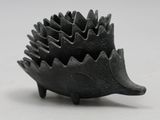 a black sculpture of a hedgehog on a white surface