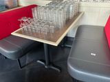 des bouteilles et des verres posés sur une table dans un restaurant avec un banc rouge