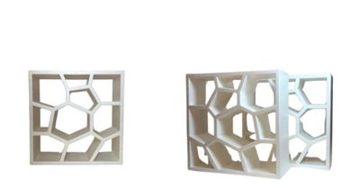 deux boîtes blanches ornées de motifs géométriques, posées sur une surface blanche