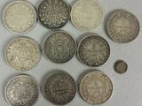 several different types of coins are arranged in a circle on a white surface