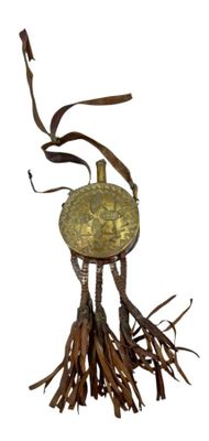 a small brass object with a tassel hanging from it ' s neck