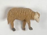 a small toy of a sheep on a white surface