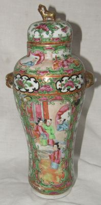 a vase that has a bird on top of it