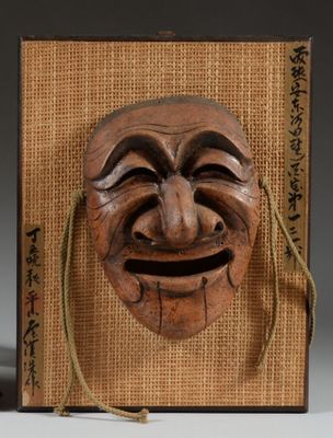 une image d'un masque en bois accroché au mur