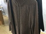 an image of a clothing rack with sweaters on it