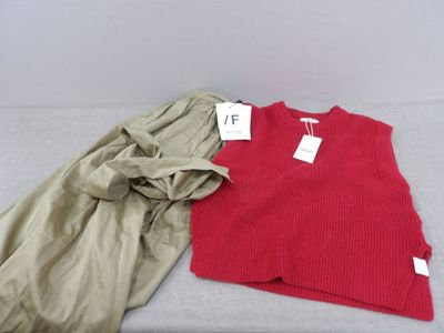 a red sweater and khaki pants sitting on a bed