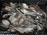 a basket full of silverware and spoons in it