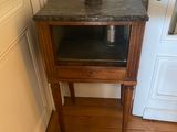 a small table with a pot on it in the corner of a room