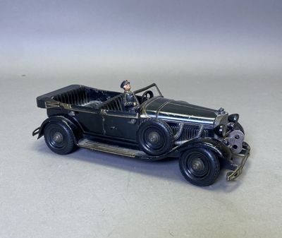 une petite voiture noire avec un homme au volant