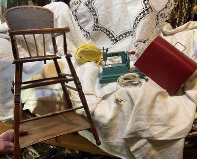 a small wooden chair sitting next to a chair on a table