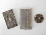 three antique silver cigarette cases and a small silver cigarette case