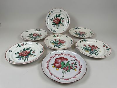 Plusieurs assiettes ornées de motifs floraux sont disposées sur une surface blanche