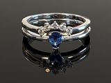 a close up of a ring on a black surface with a blue stone