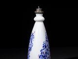 blue and white porcelain bottle on a black surface with a black background