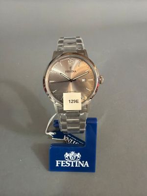 la montre est posée sur un socle auquel est attachée une étiquette bleue