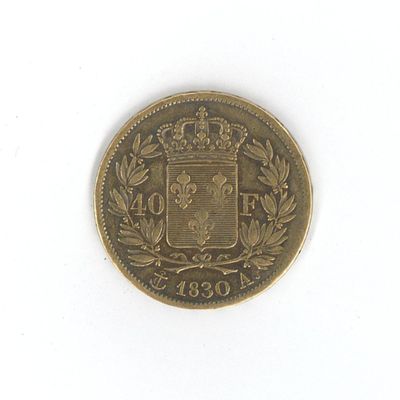 une vieille pièce de monnaie sur laquelle figurent des armoiries et une couronne