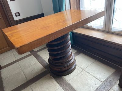 a wooden table with a bench in front of a window